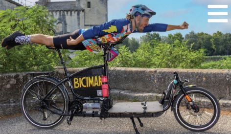 Visual showing a man on top of a bicycle in a horizontal position. Photo taken for the photo exhibition "Portraits in the saddle".